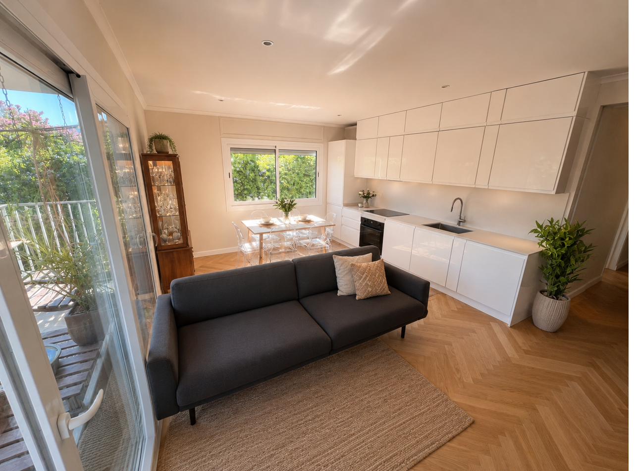 Sala d'estar oberta amb cuina, menjador i parquet espina de peix